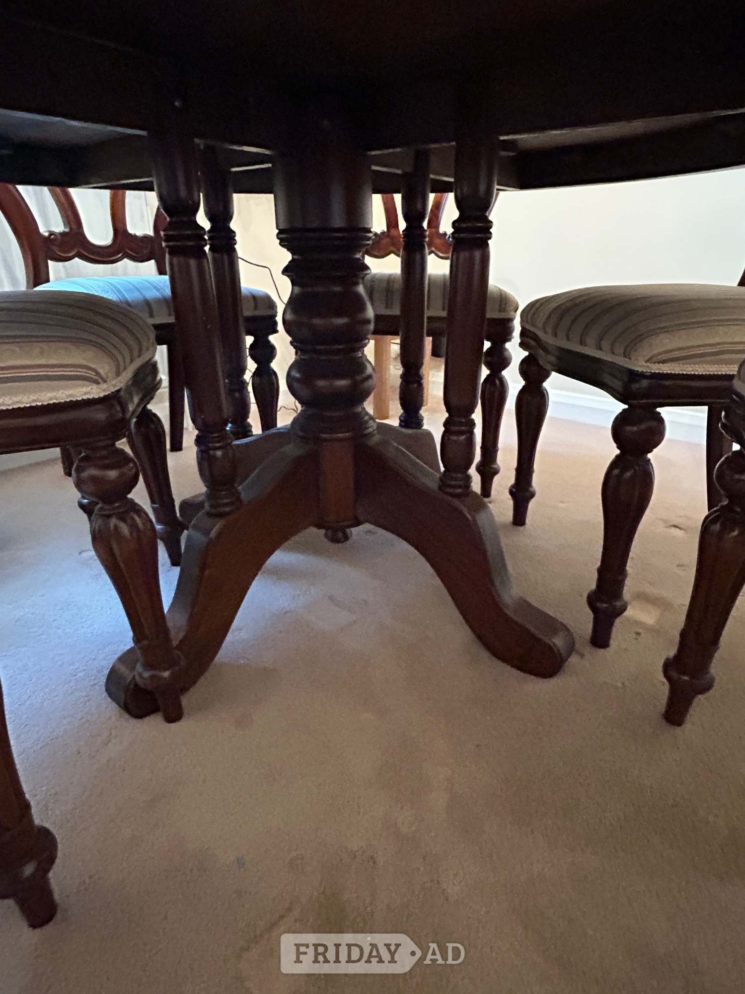 Mahogany round dining room table with 6 matching chairs.