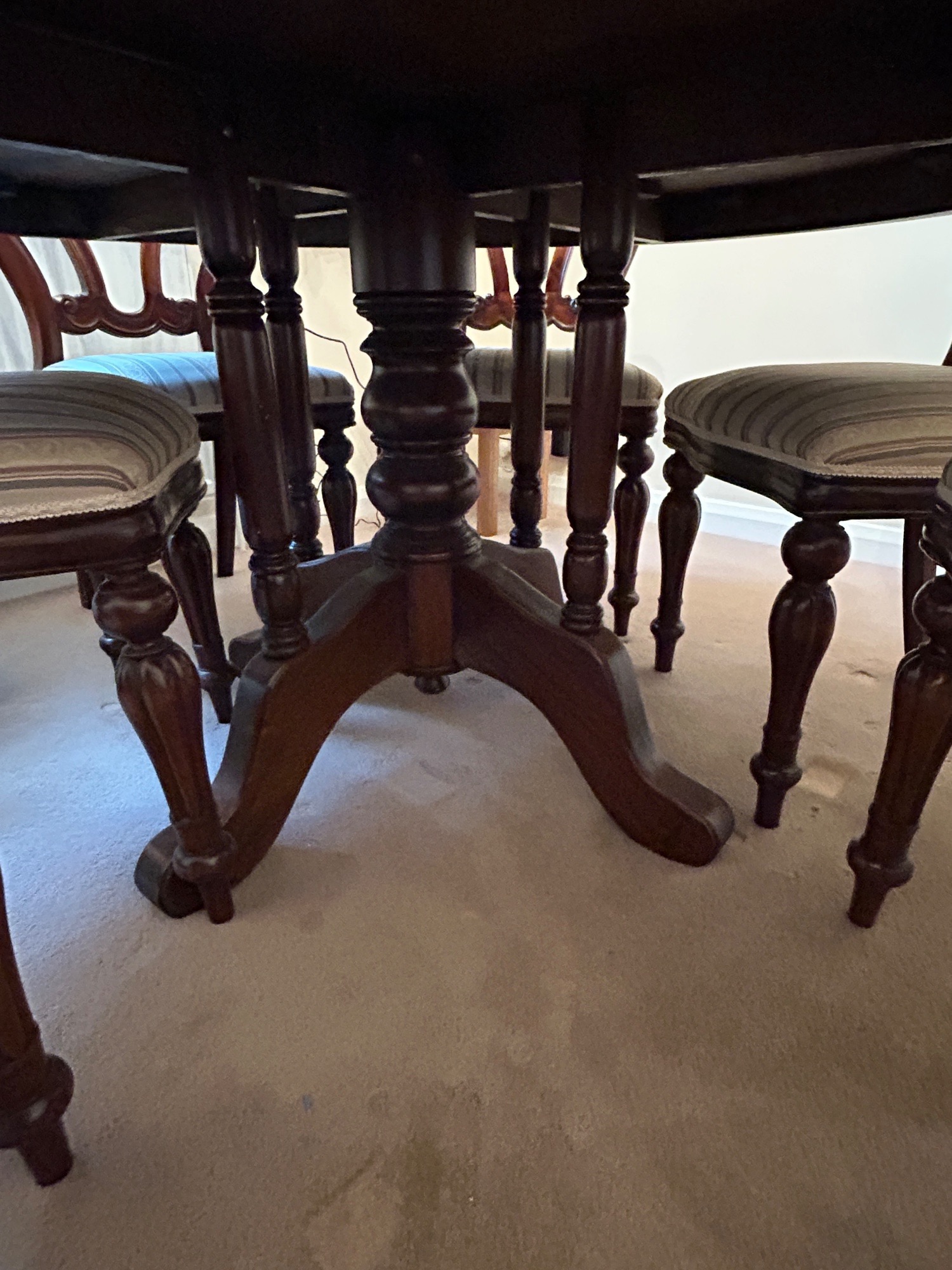 Mahogany round dining room table with 6 matching chairs.