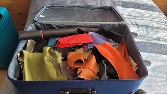 Large suitcase of brightly coloured leather offcuts