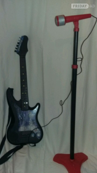 Toy guitar with microphone and stand in Pulborough