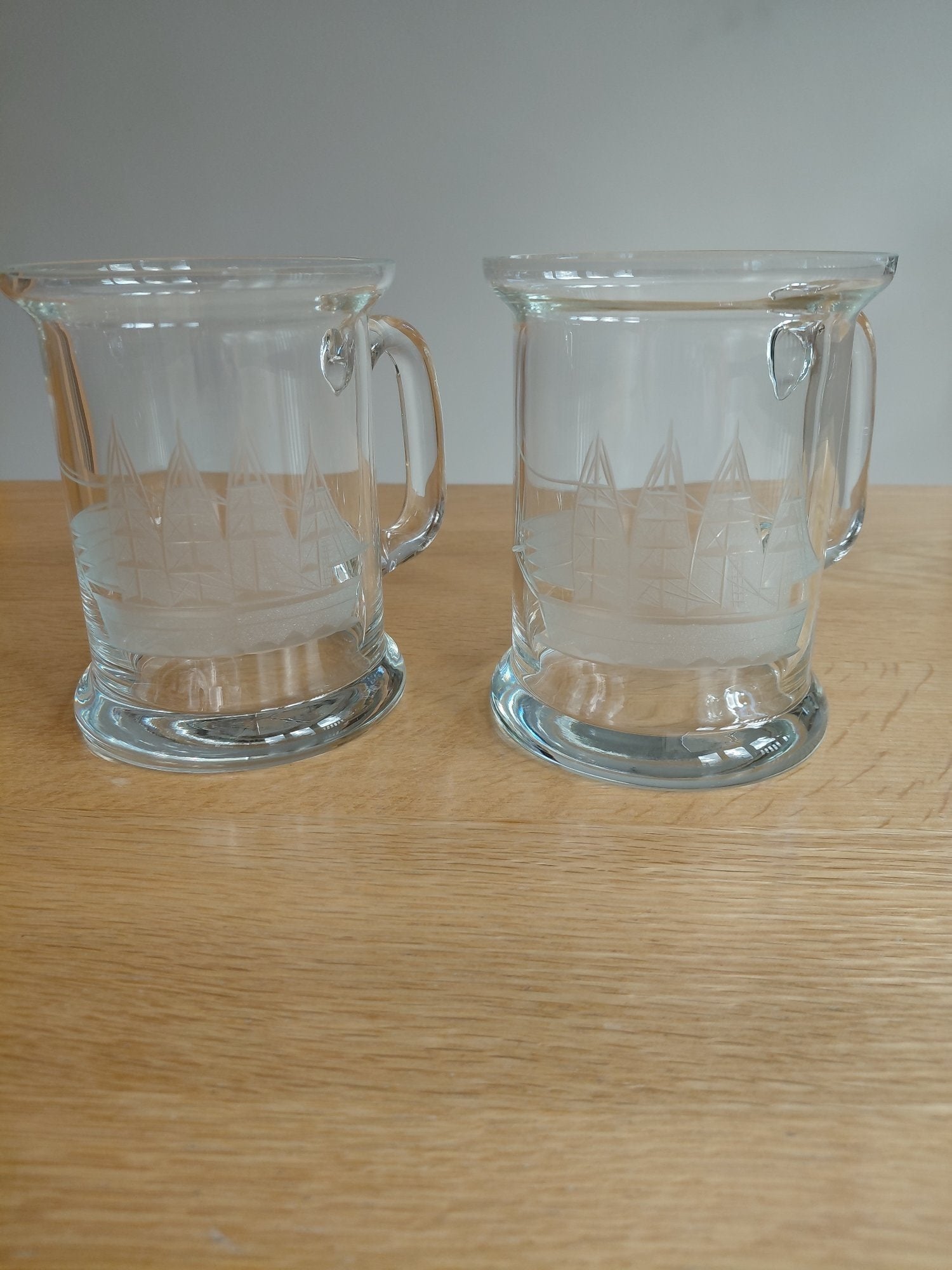 Pair of Glass Tankards with Etched Ship Design – Good Condition