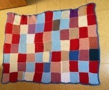 Hand-knitted multicolour patchwork blanket for children