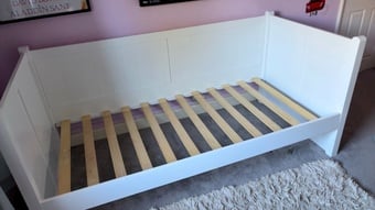 White daybed with mattress and pullout under bed. 