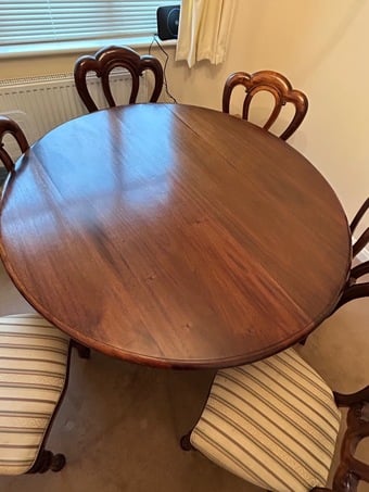 Mahogany round dining room table with 6 matching chairs.