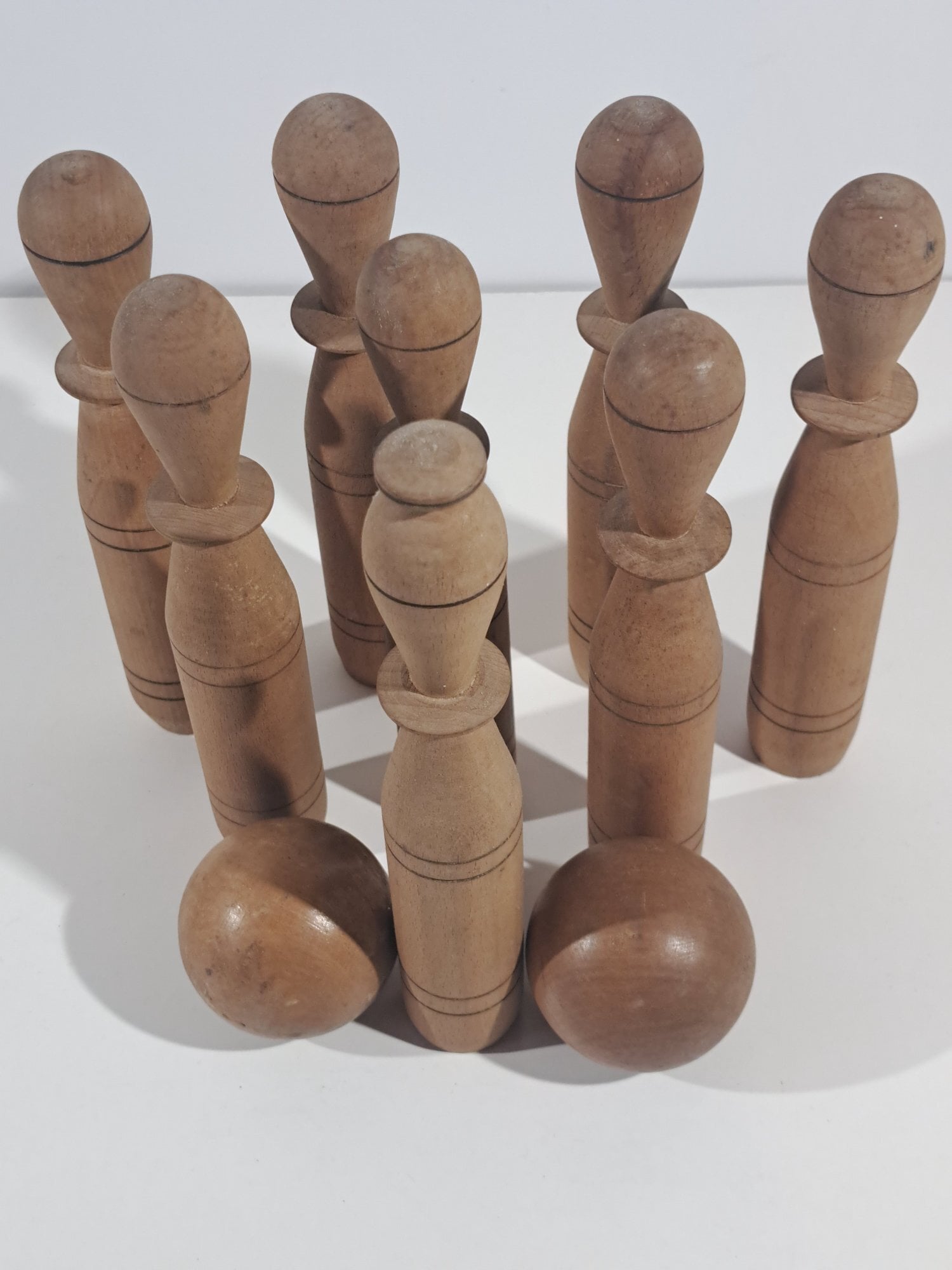 WOODEN SKITTLES AND BALLS ON STAND. ANTIQUE BOWLING GAME