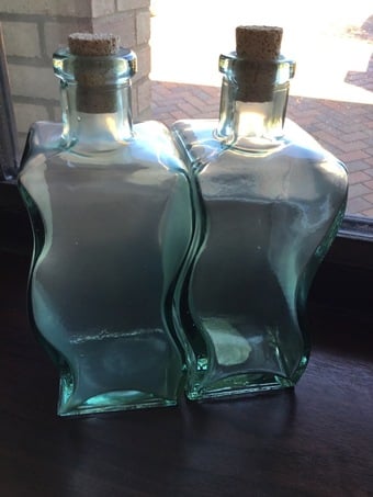 2 waved heavy glass bottles with cork stoppers