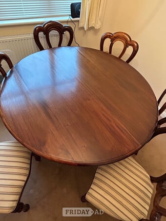 Mahogany round dining room table with 6 matching chairs.