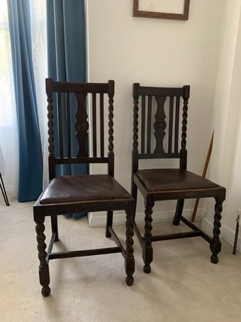 Two dark wood vintage chairs with barley twist legs and leather seats